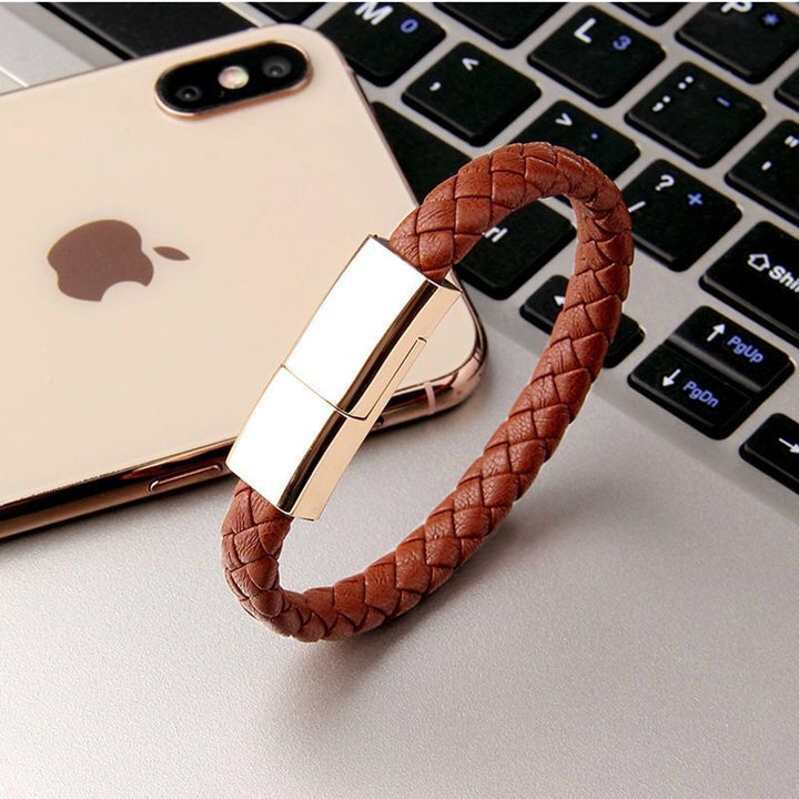 Brown braided USB drive on a laptop keyboard with an iPhone in the background